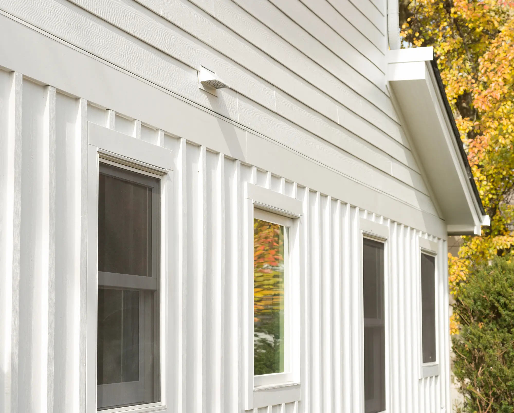 Modern home with clean white vertical siding and windows