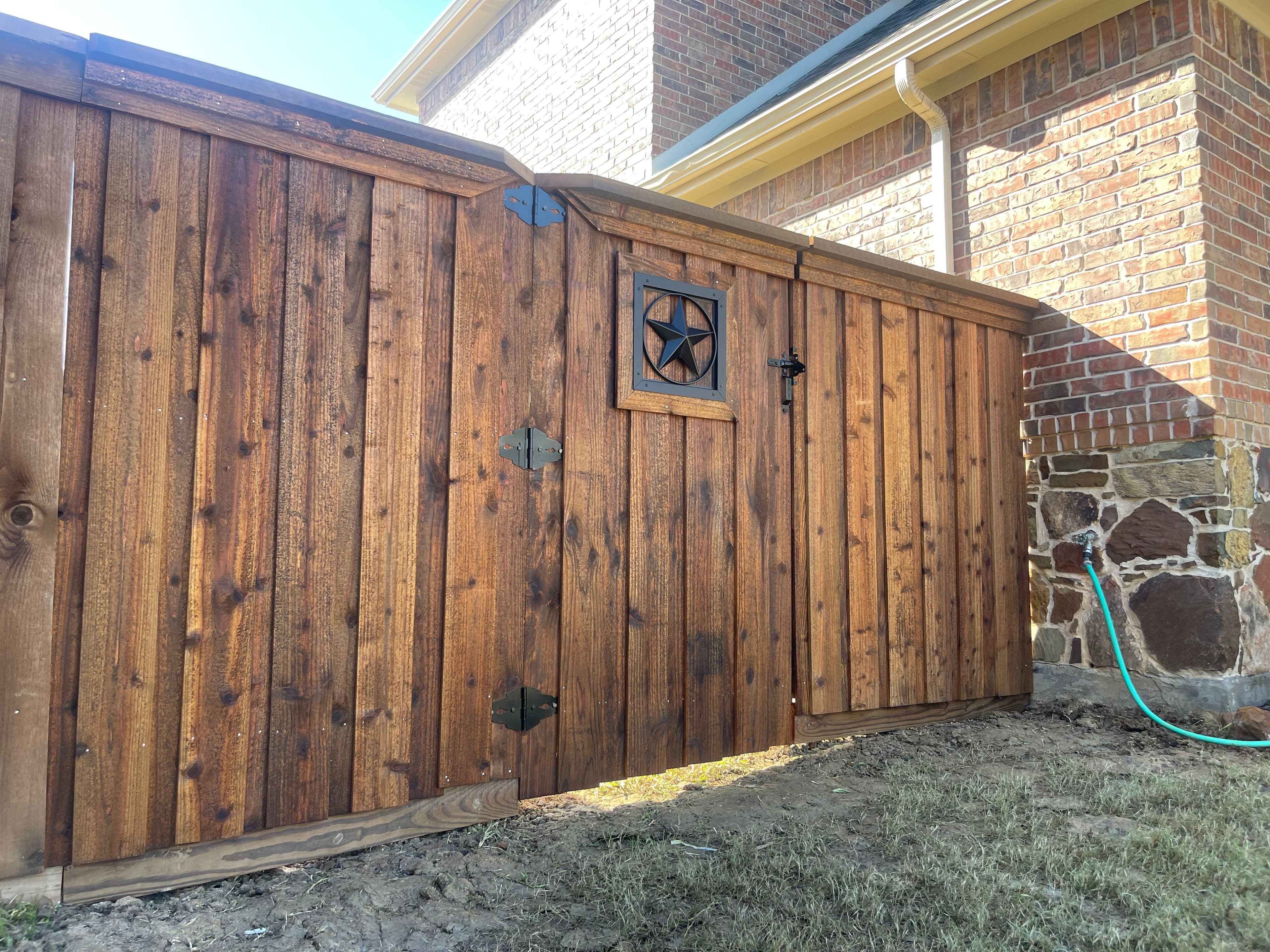 Wooden fence gate with decorative Texas star emblem
