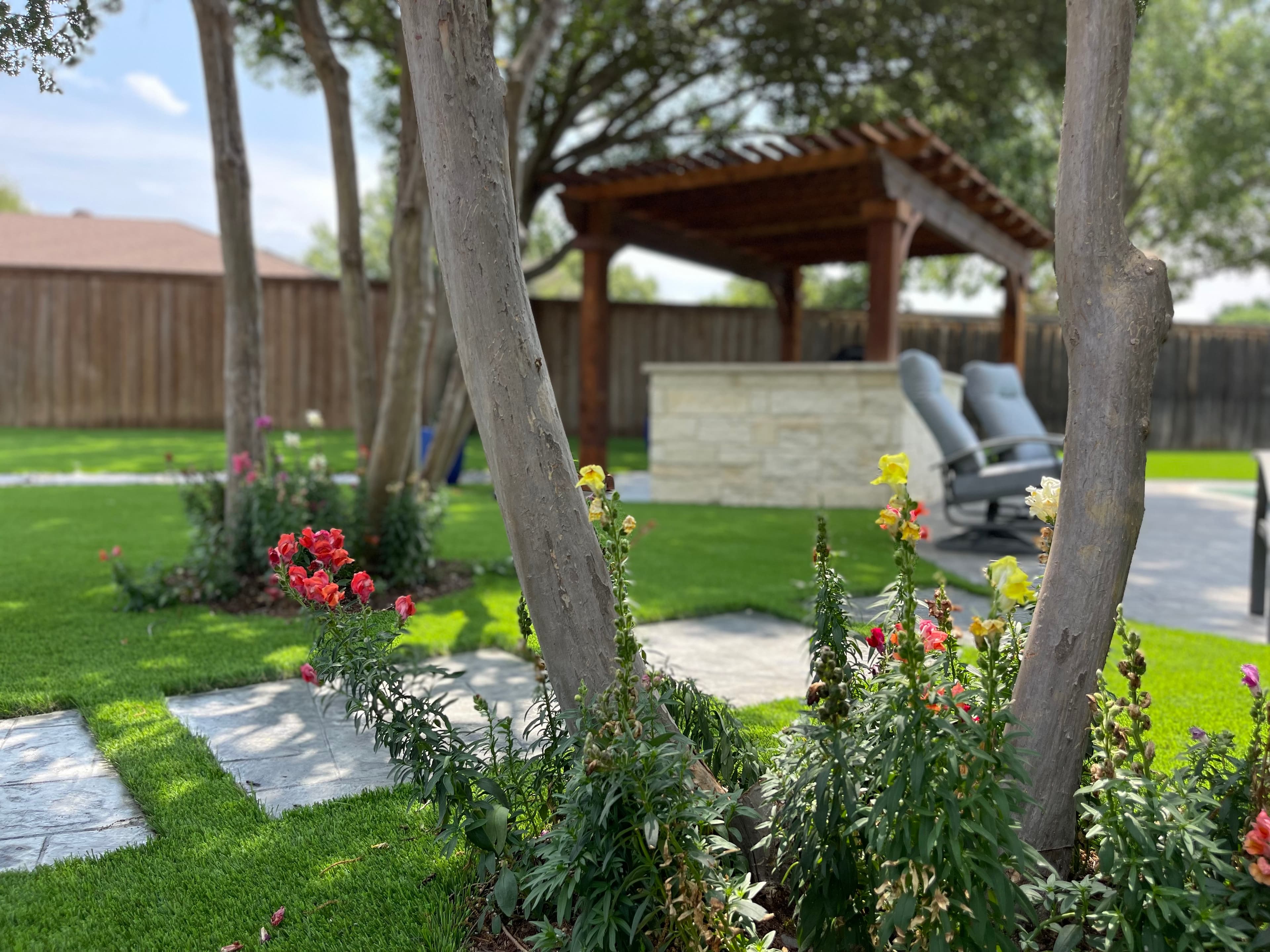 Backyard with pergola, artificial turf and outdoor kitchen
