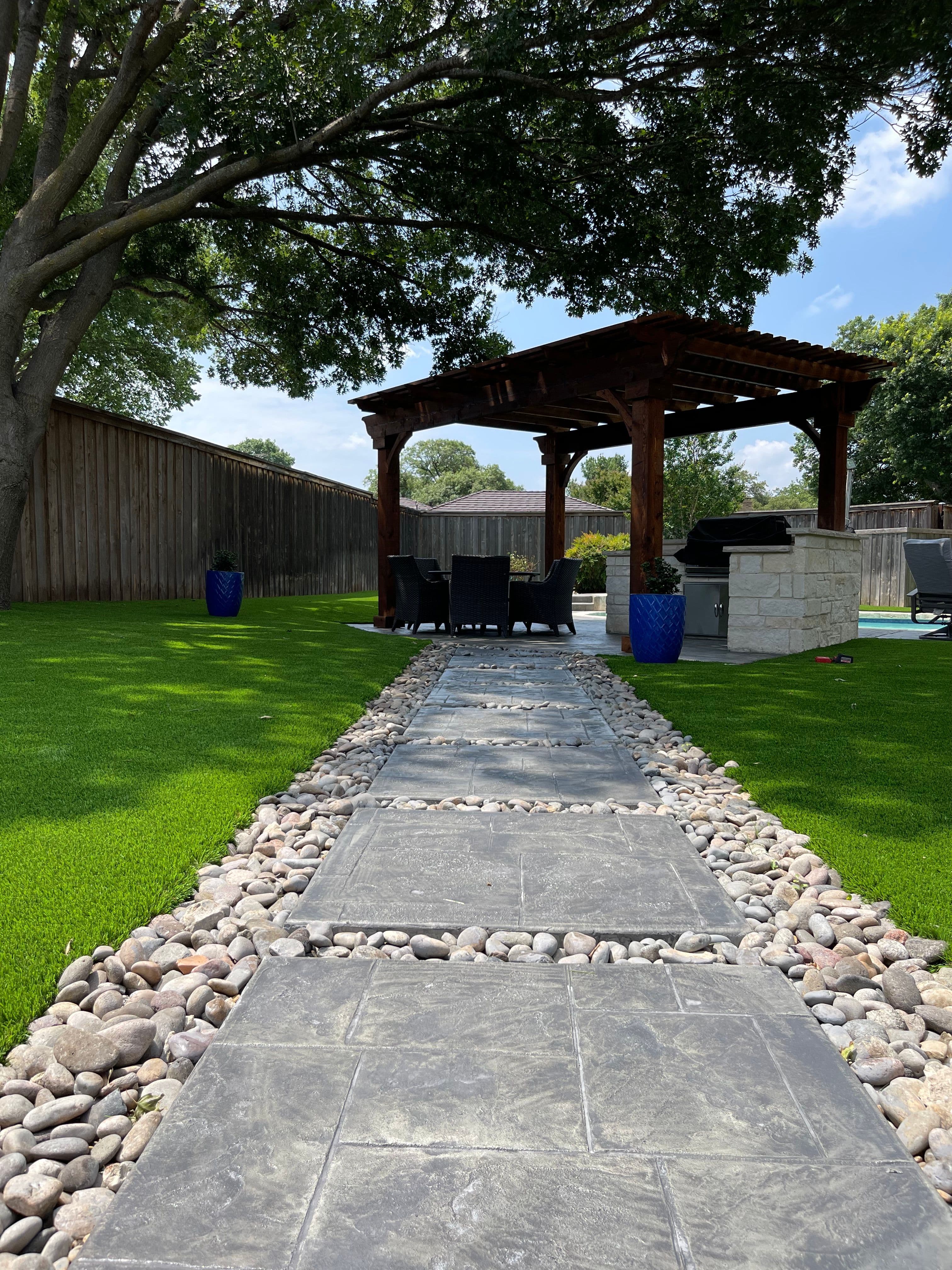 Stone pathway with pergola and outdoor kitchen
