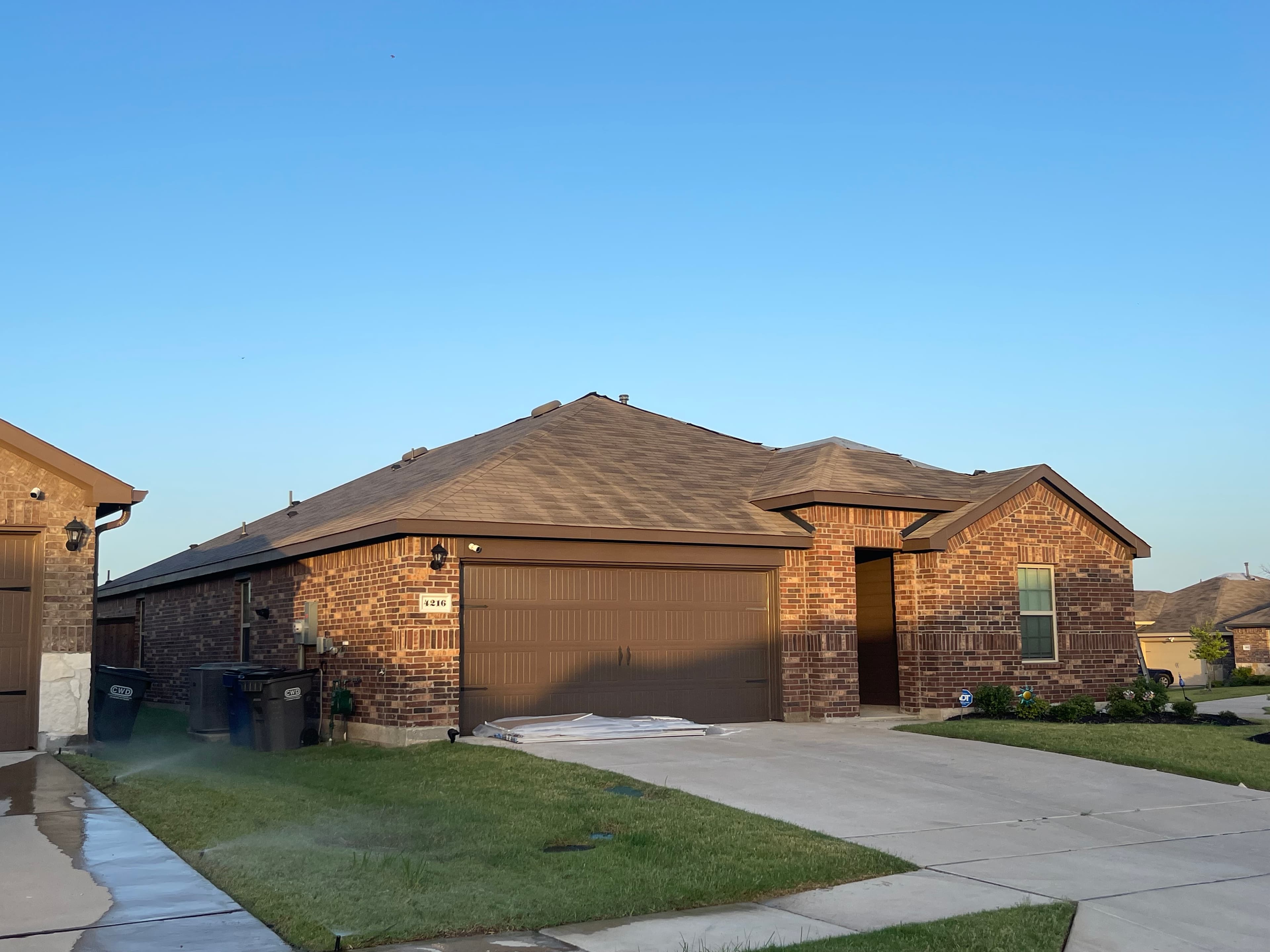 Single-story brick home with brown shingle roof