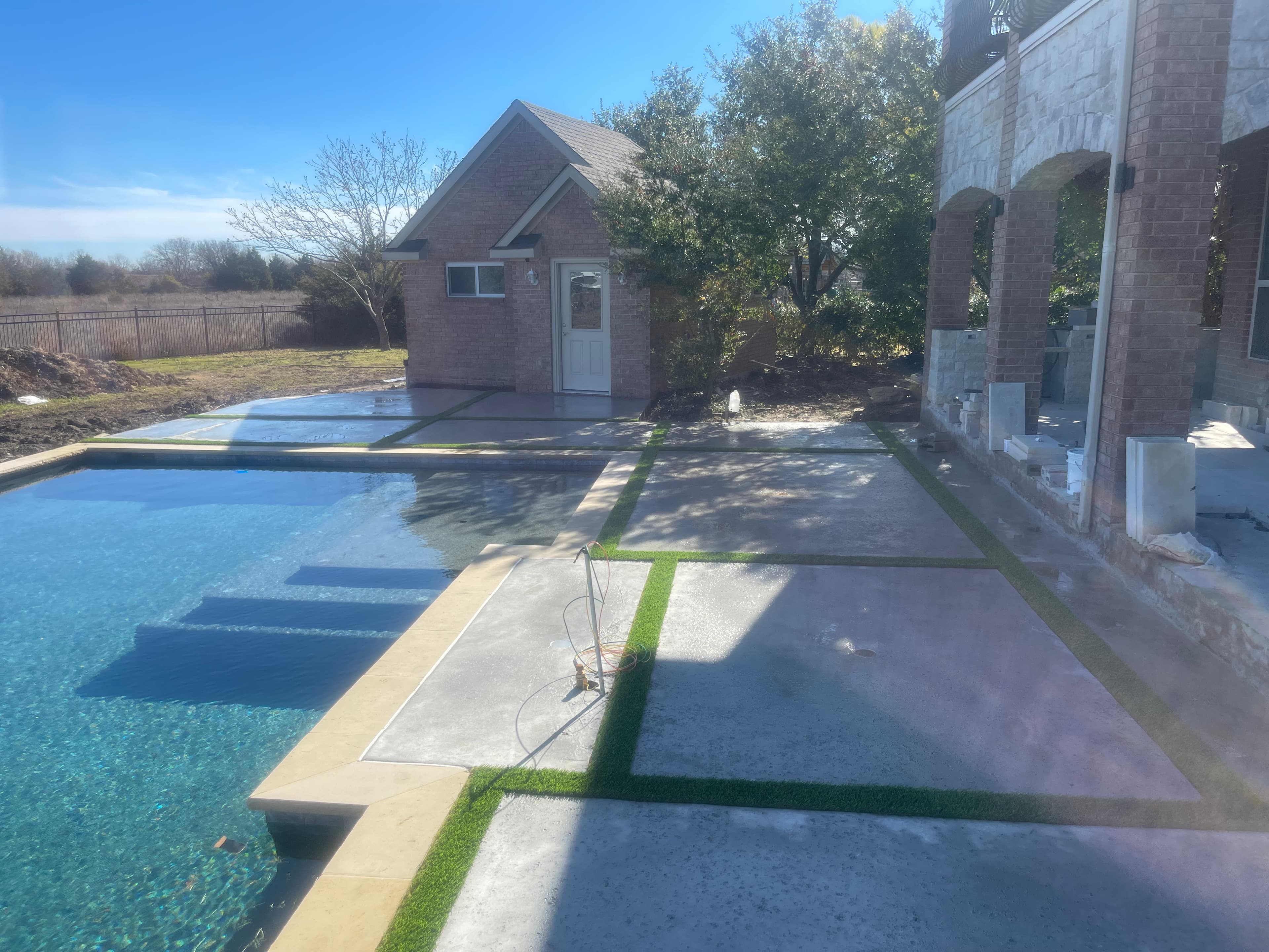 Poolside artificial turf with concrete design elements