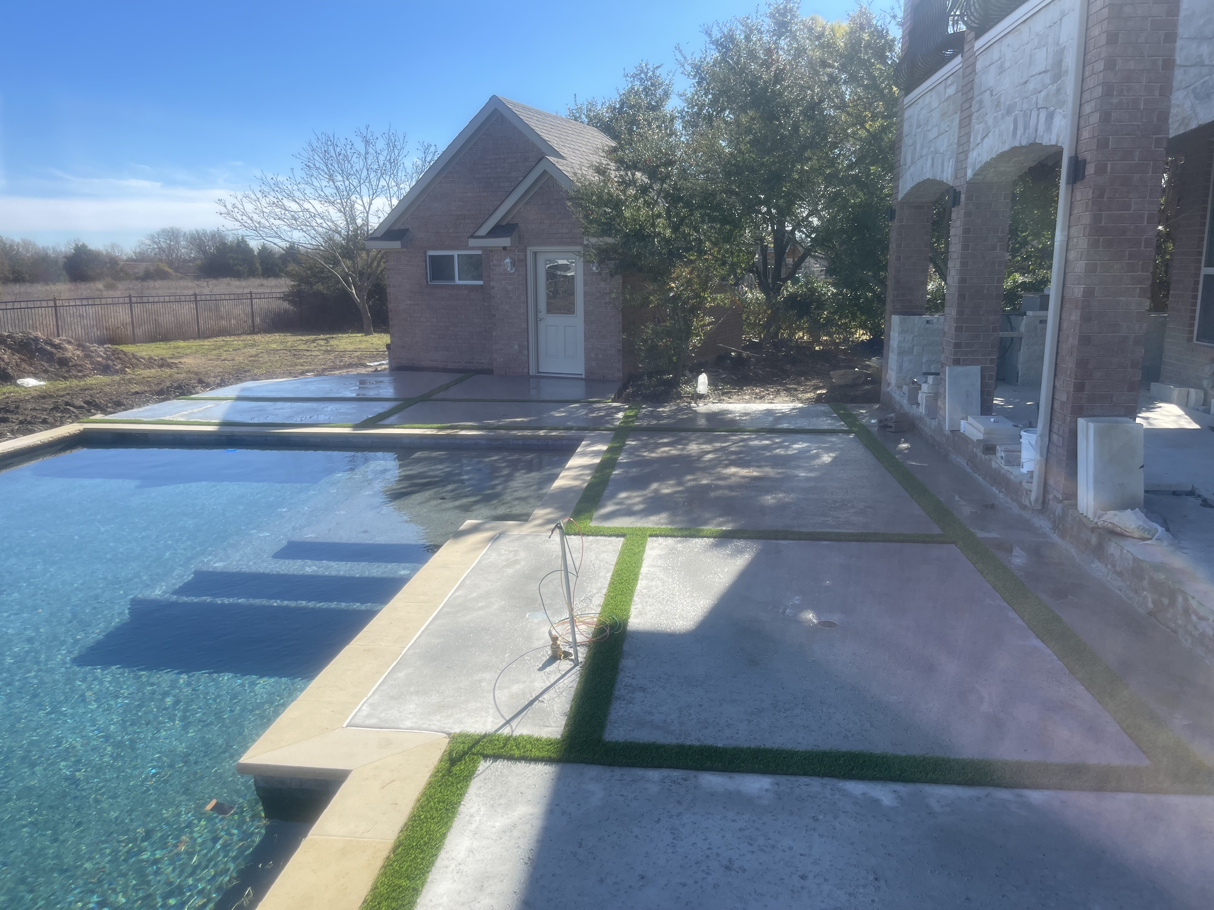 Poolside artificial turf with concrete design elements